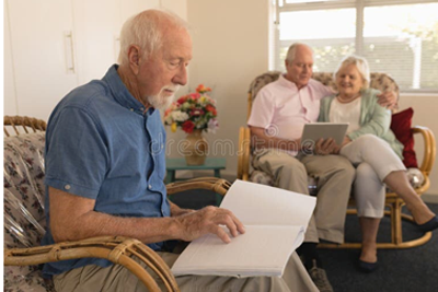 seniors in living area, man reading braille, others reading tablet